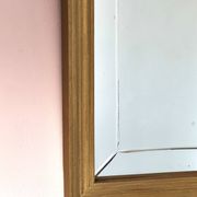 Miroir en bois doré, de forme organique avec une glace biseauté