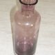 Plum-colored glass bottle with bubble