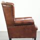 Sheepskin wingback armchair in a warm cognac colour with refined nailhead trim