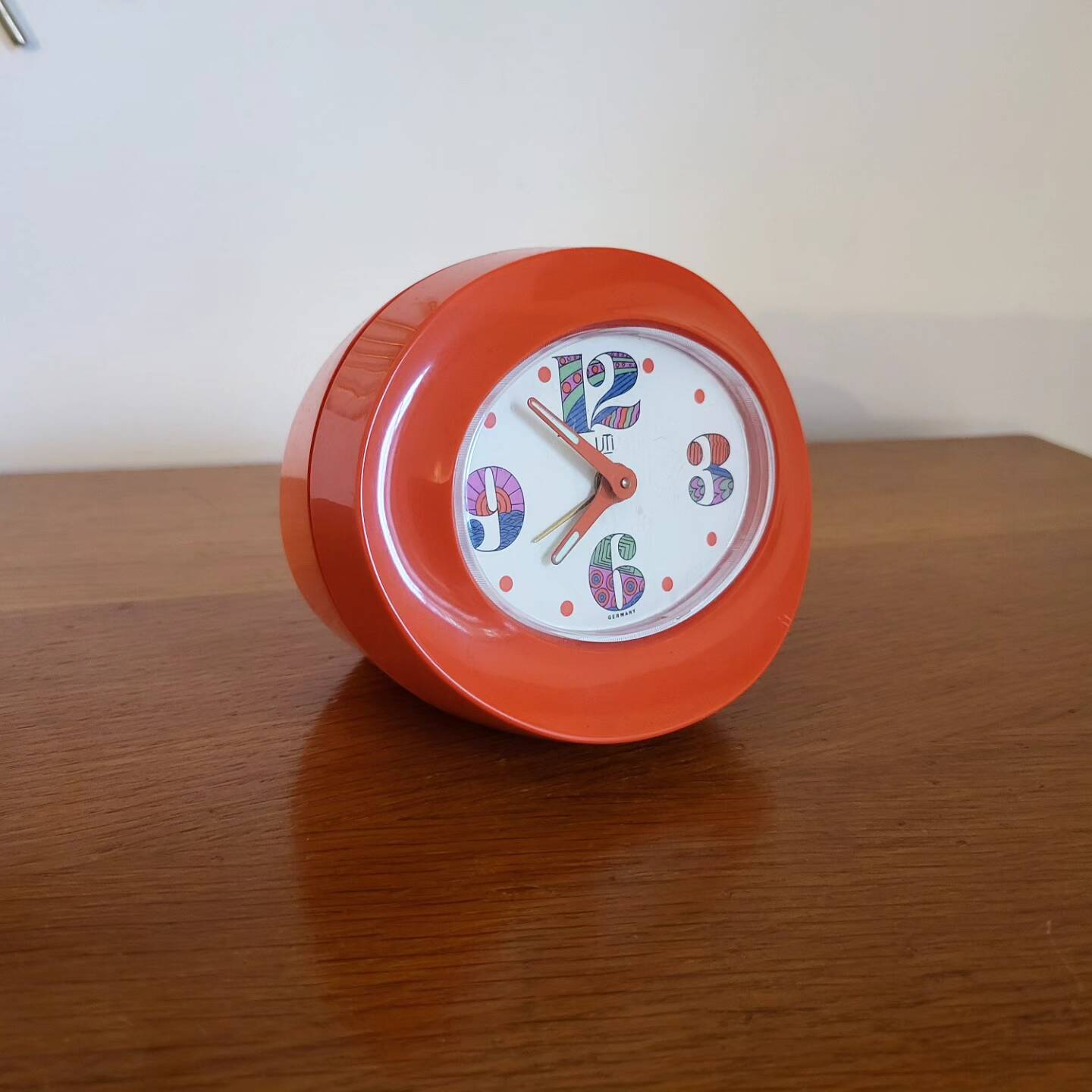 Vintage mechanical alarm clock in orange plastic Uti West Germany