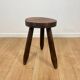 Small brutalist tripod stool in solid wood.