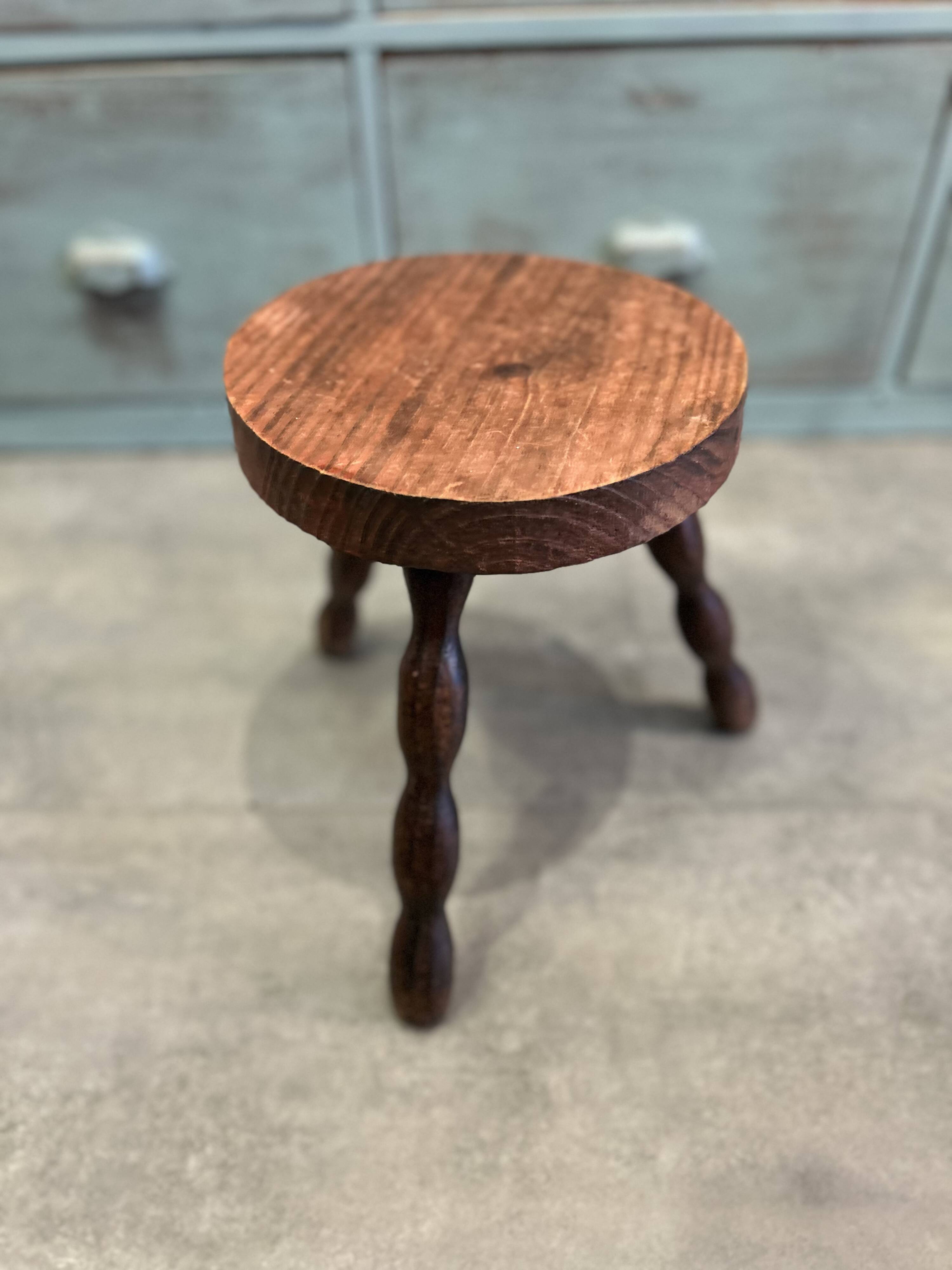 Three-legged stool with beaded wooden legs