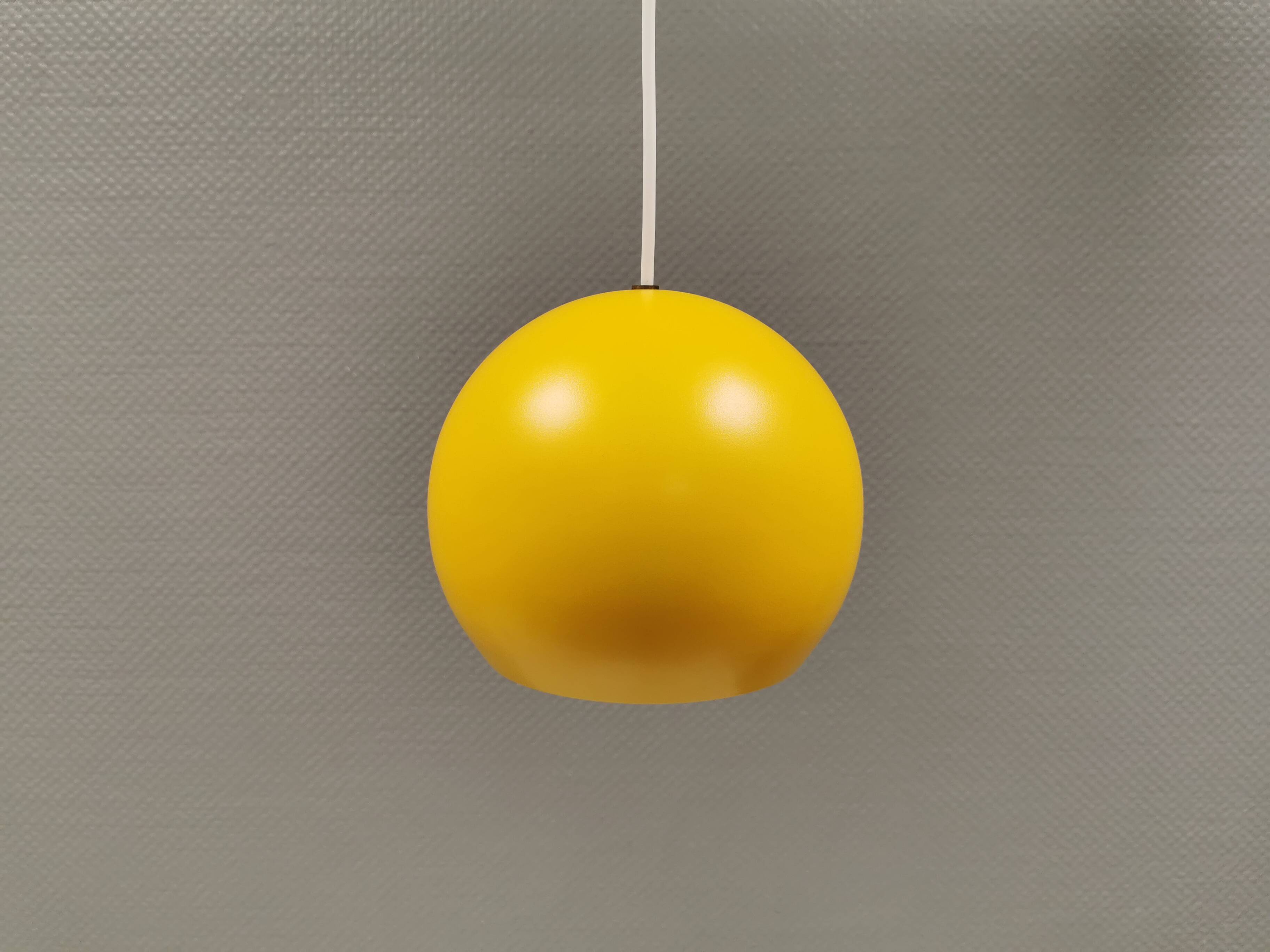 Spherical pendant lamp in sunny yellow.