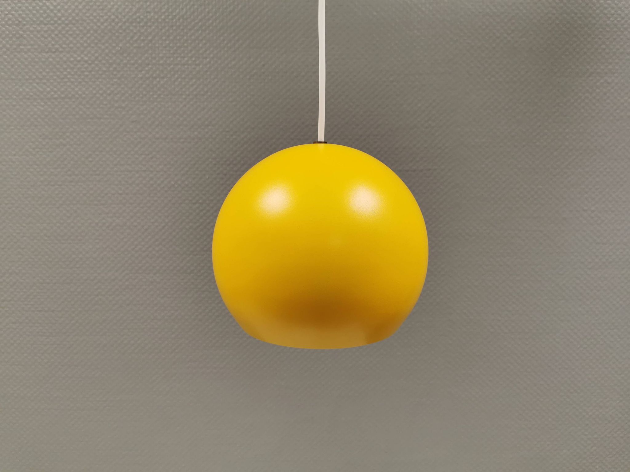 Lampe suspendue sphérique en jaune ensoleillé.