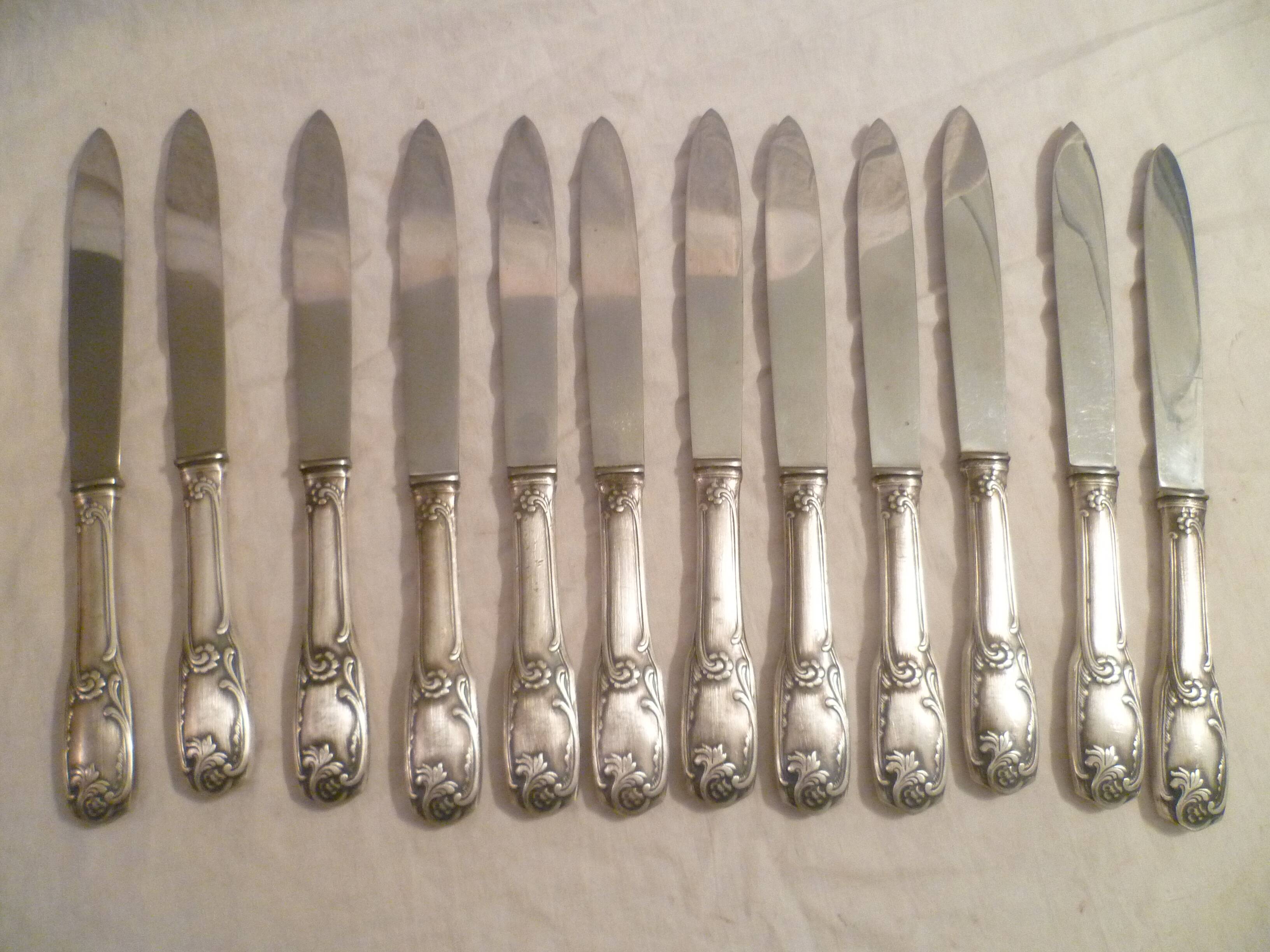 12 couteaux de table en metal argente modele "feuillages" lames inox