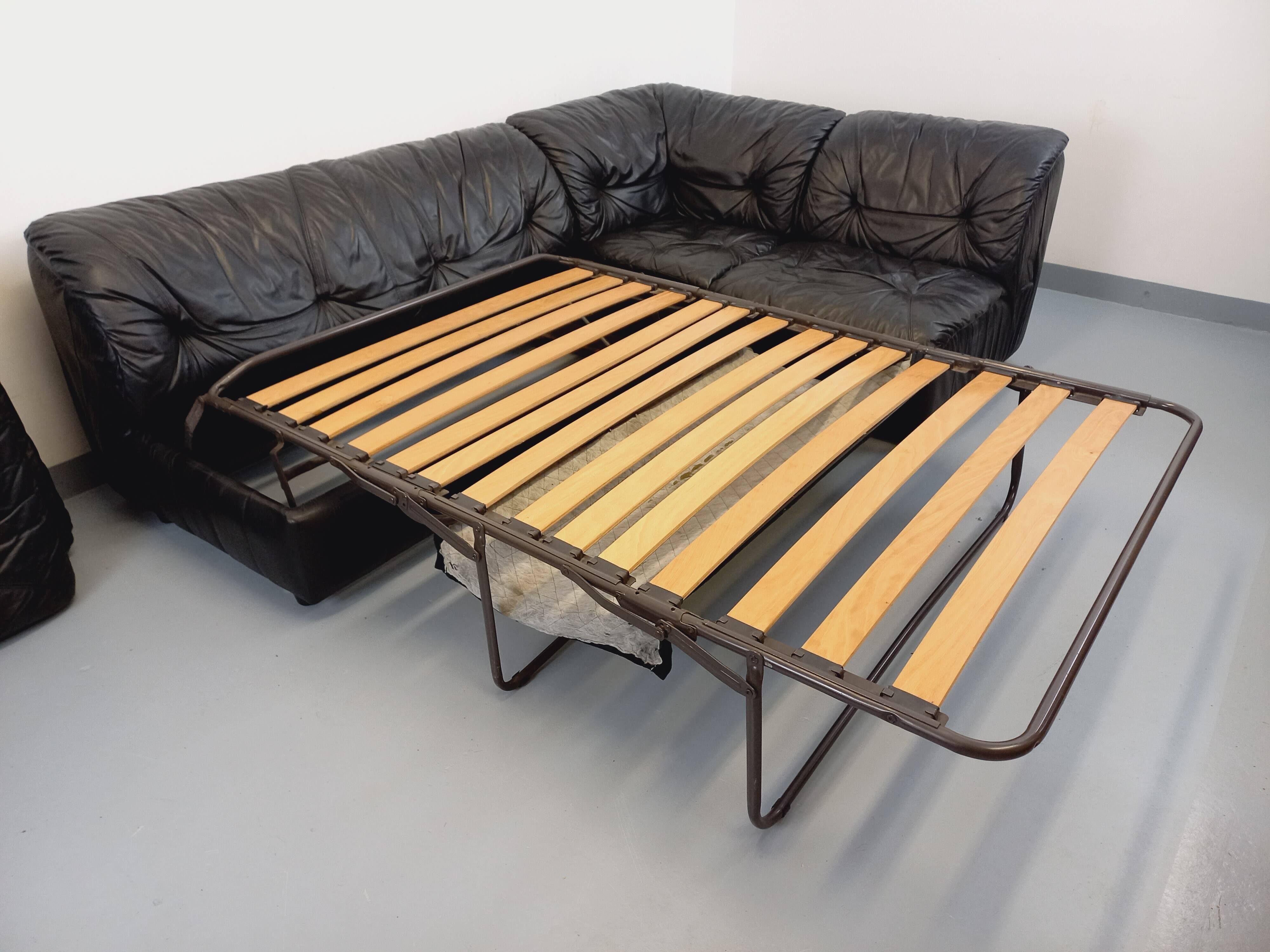 Vintage corner sofa composed of 3 modules in black leather with integrated bed.