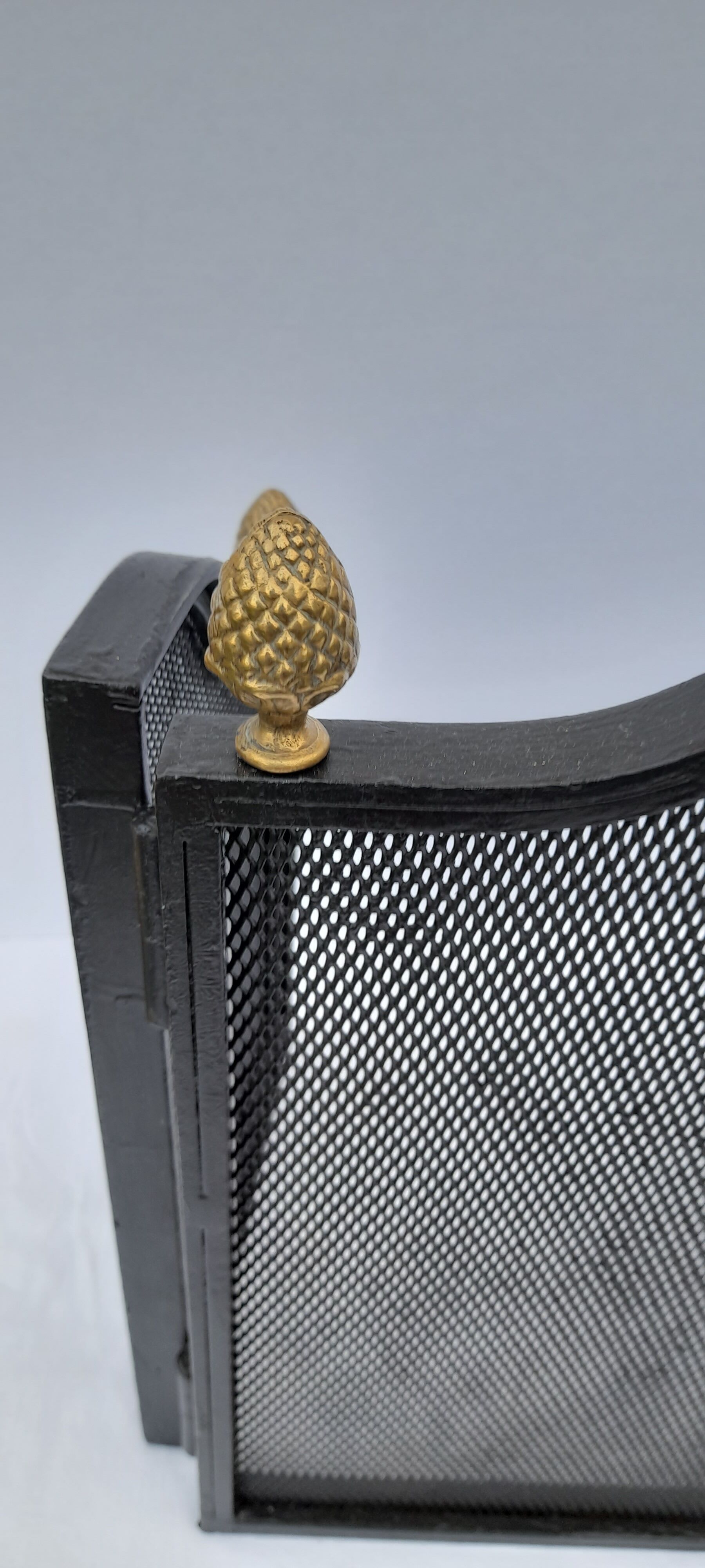 Wrought iron wire fenced fire with brass pine cone