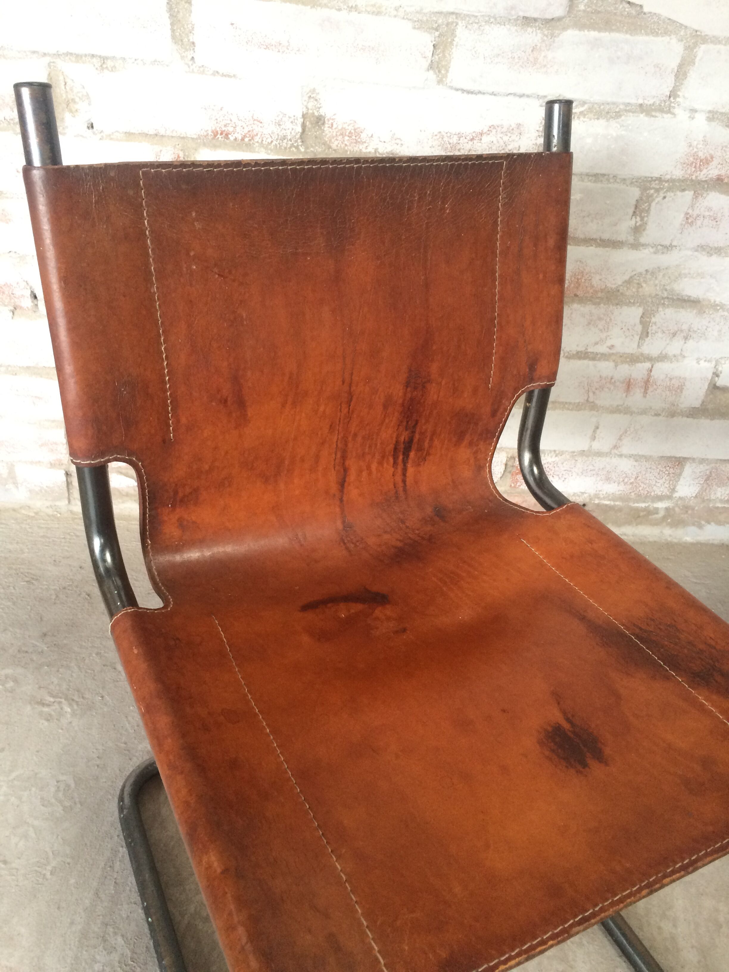 pair of tubular chairs in tawny leather