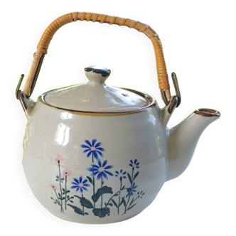 Flowery stoneware teapot with rattan handle.