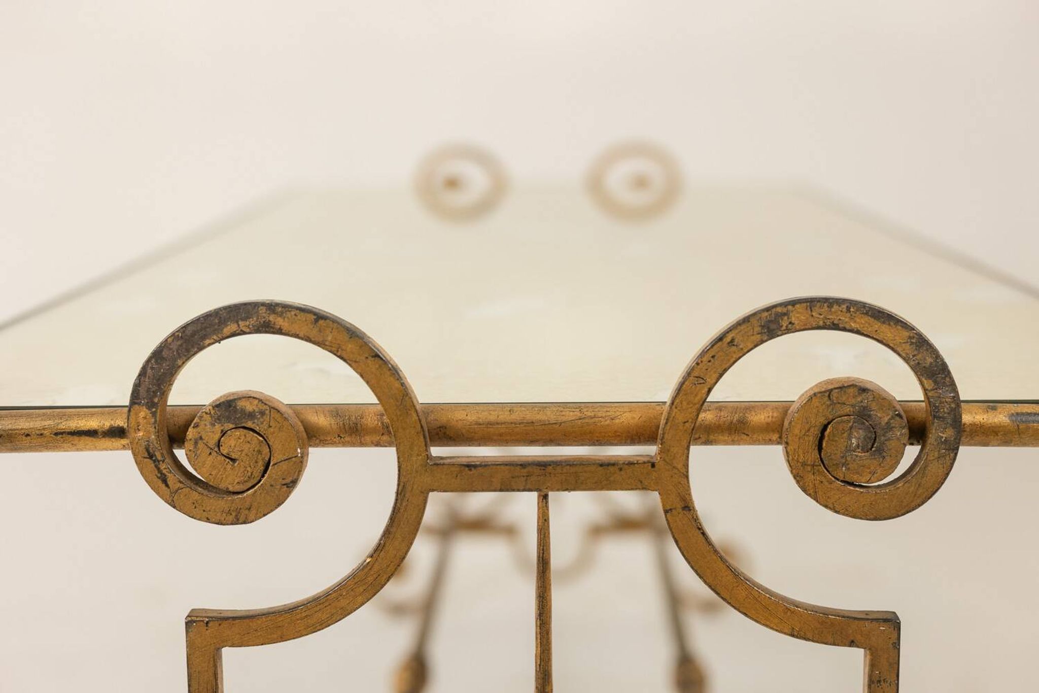 Table basse en fer forgé doré et plateau de verre églomisé. Années 1970