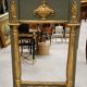 Empire-style mirror in deep green lacquered wood richly enhanced.