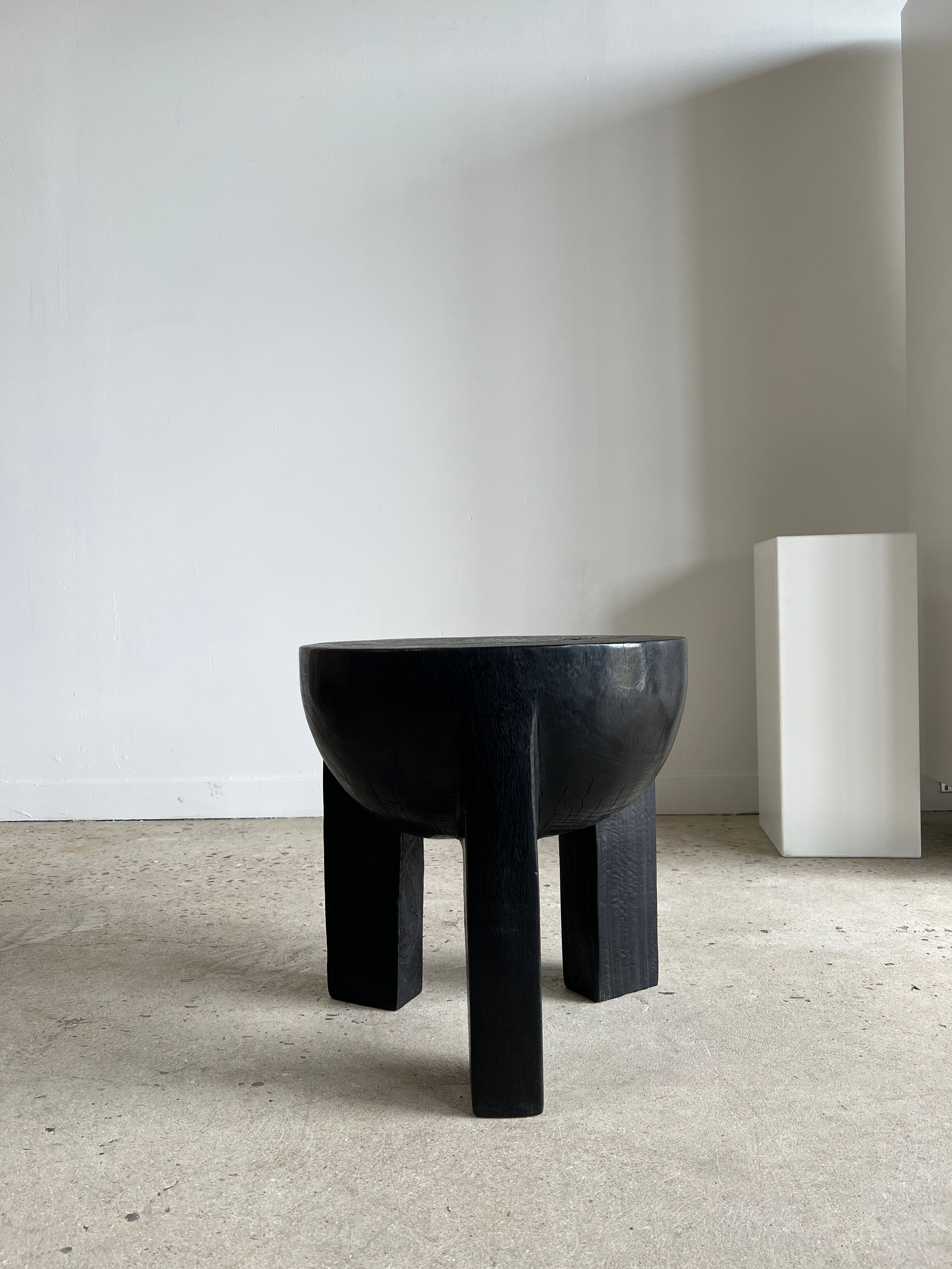 Black mango wood tripod side table with a semi-spherical top, height: 45 cm, diameter: 44 cm.