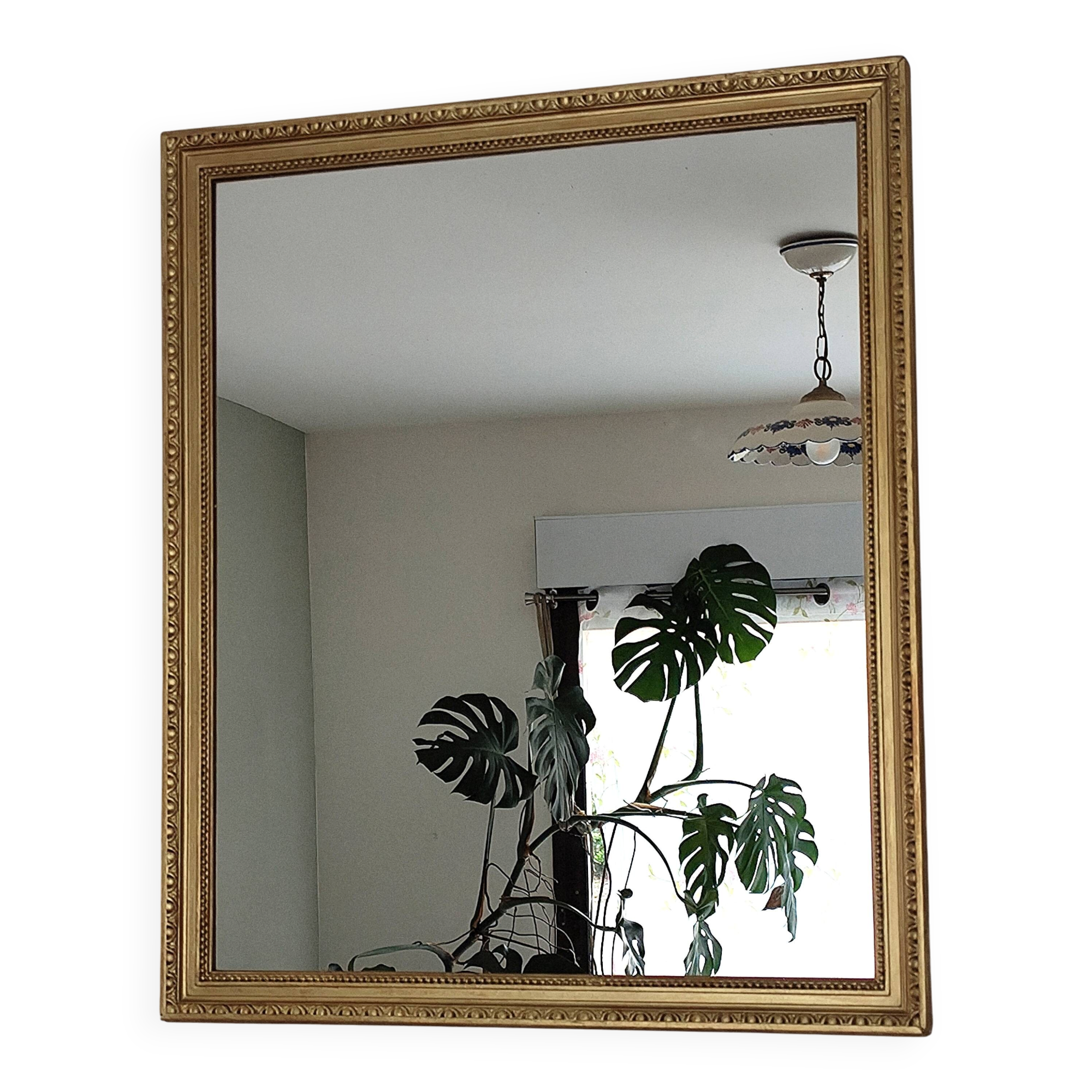 Antique mirror with a gilded frame and beaded border.