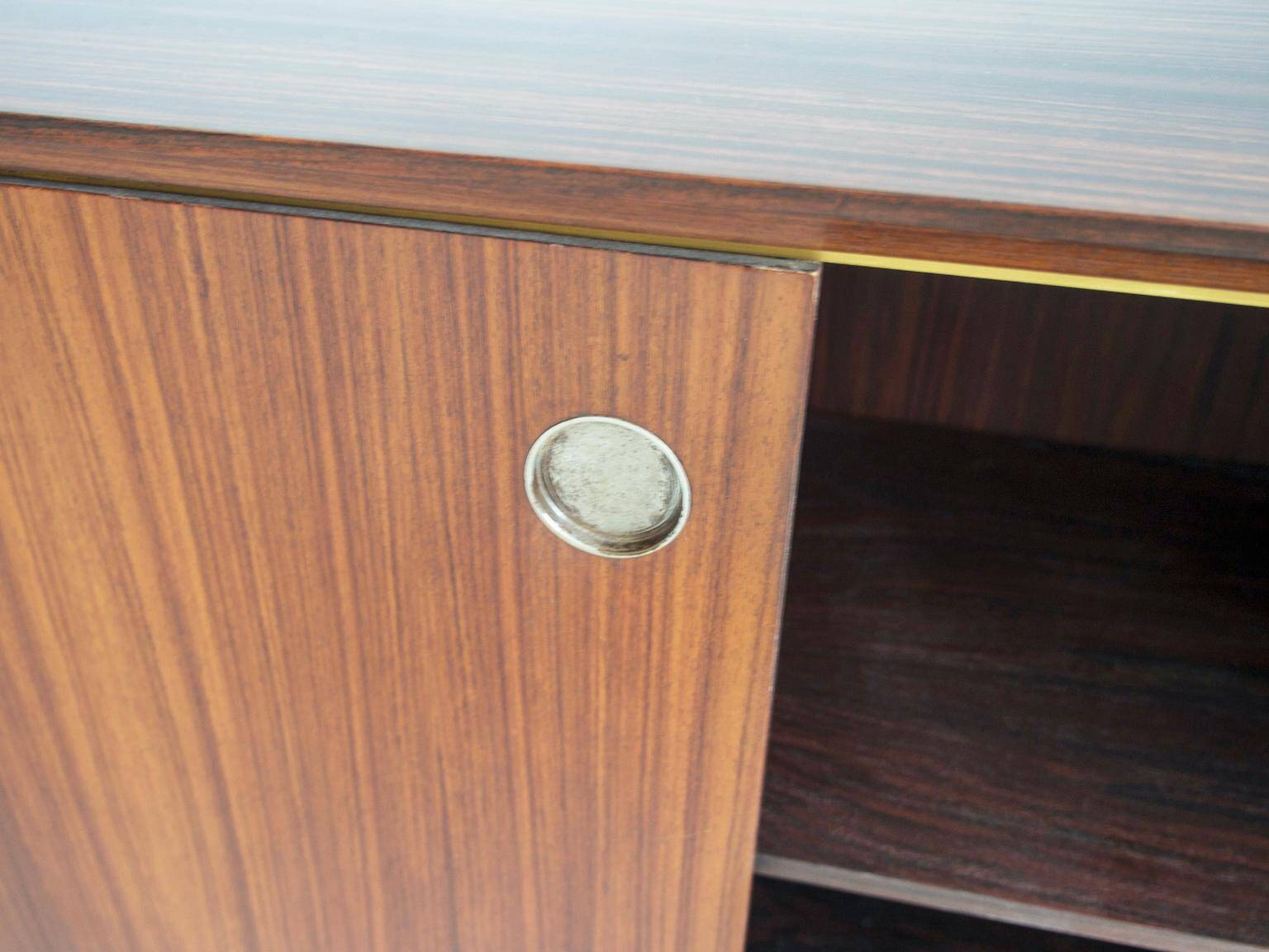 Wooden sideboard with sliding door and white drawers, around 1960.