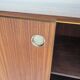 Wooden sideboard with sliding door and white drawers, around 1960.