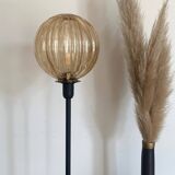 Table lamp with a gold-trimmed globe and a black base