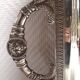 Silver-plated service tray with handles, neoclassical decoration.