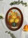Painting of flowers in an oval frame.