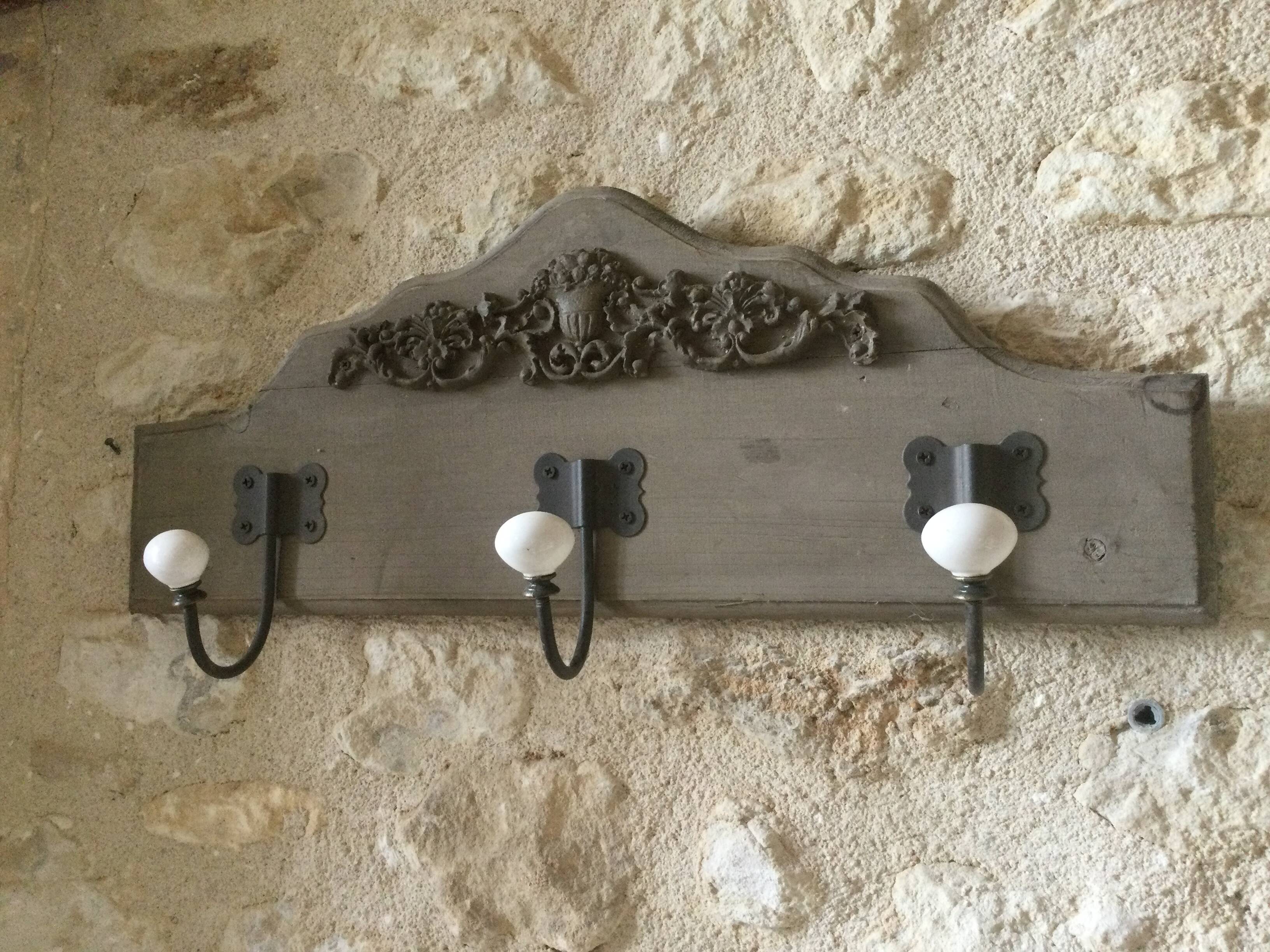 Wall-mounted wooden coat rack with 3 hooks.