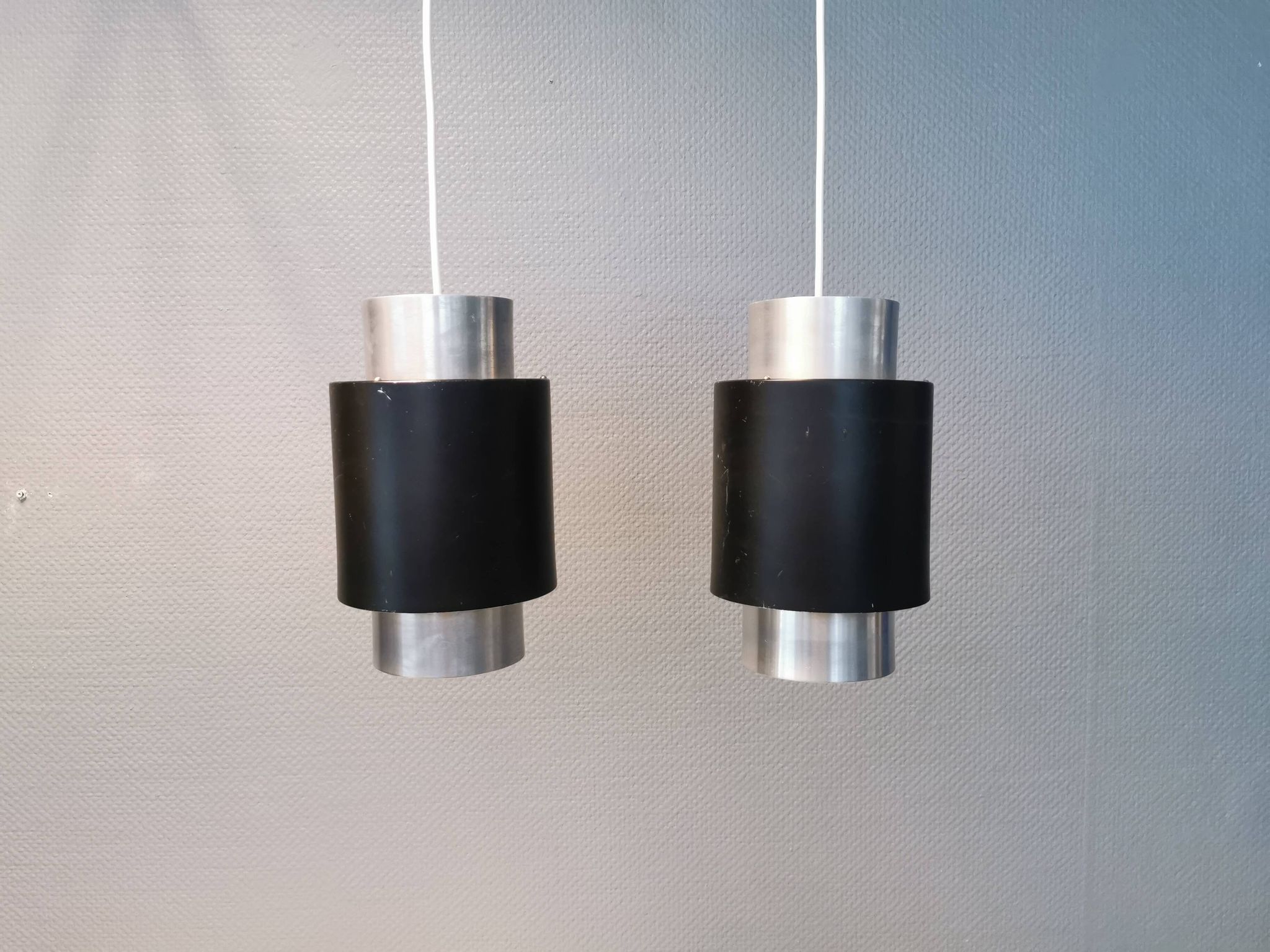 A set of beautiful cylinder shaped hanging lamps in silver color with black "ring" Danish 1970s.