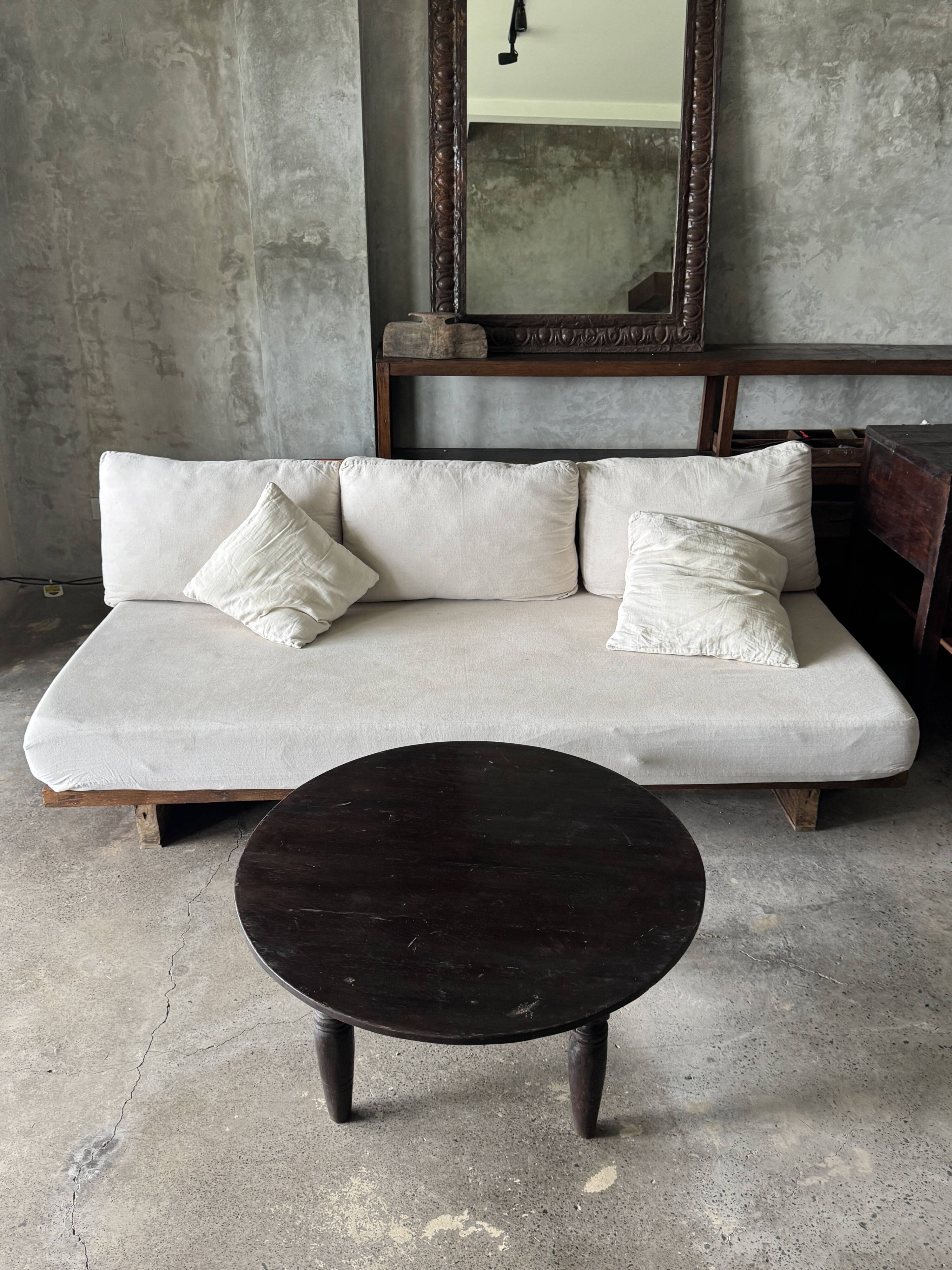 Antique round coffee table in Indonesian teak with turned legs.