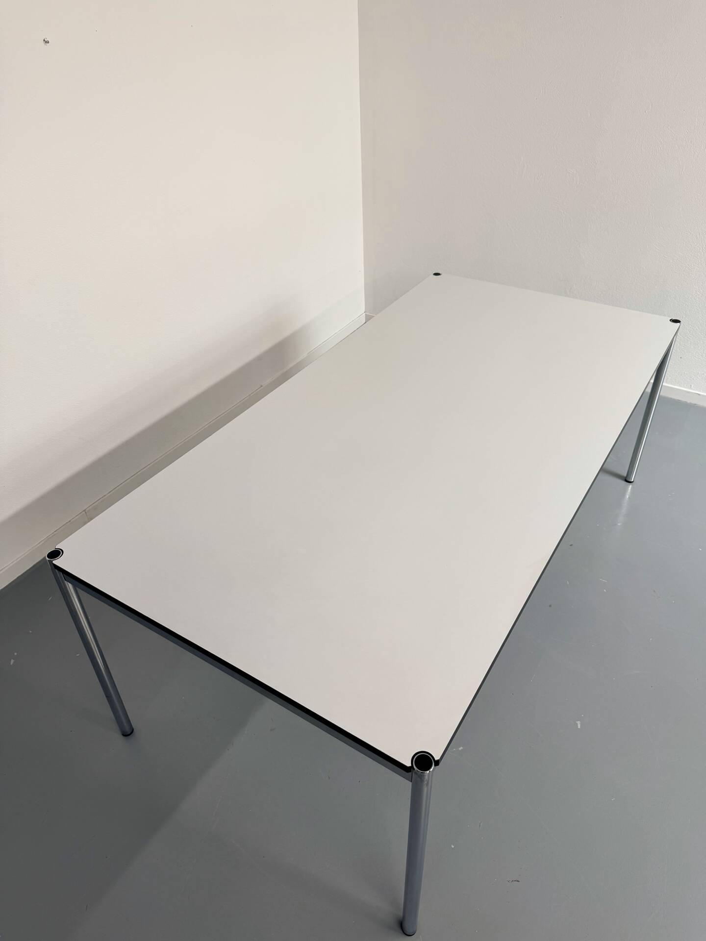 Large table design USM Haller with a white top and chrome structure.