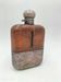 Silver-plated metal flask with leather and glass