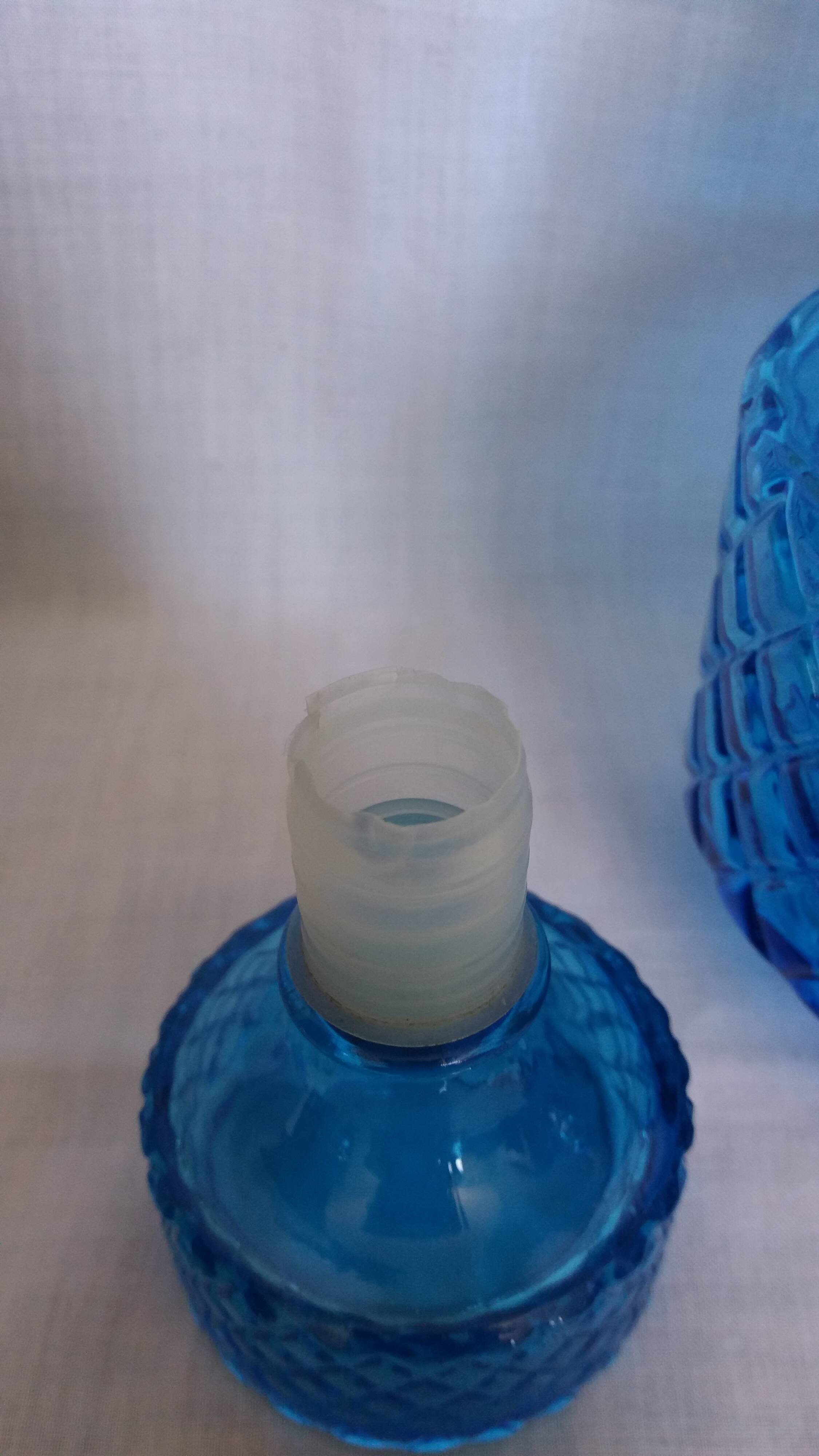 Turquoise glass carafe bottle with a stopper.