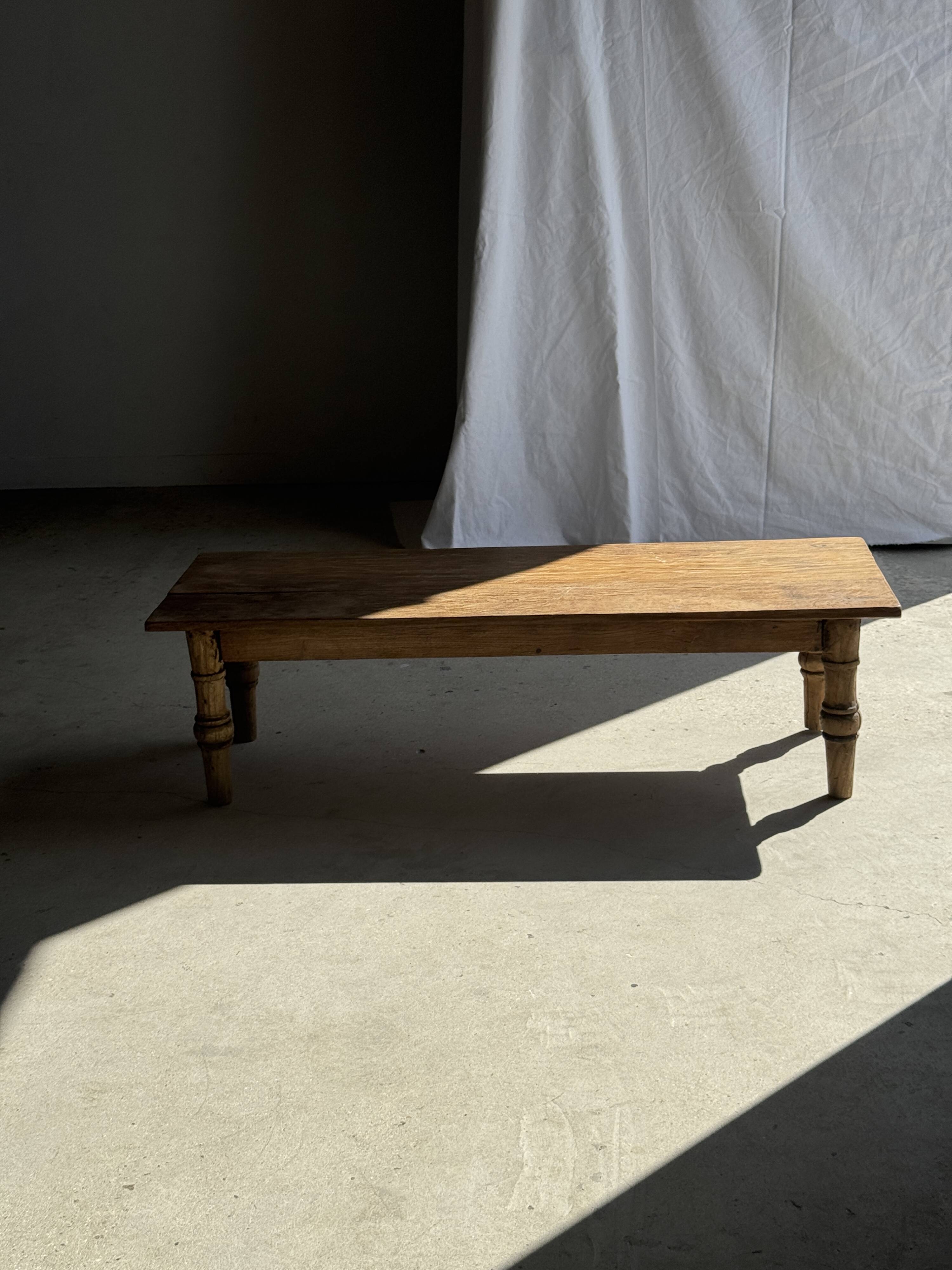 Brown Indonesian teak coffee table, with a border and cylindrical legs H40 L103.