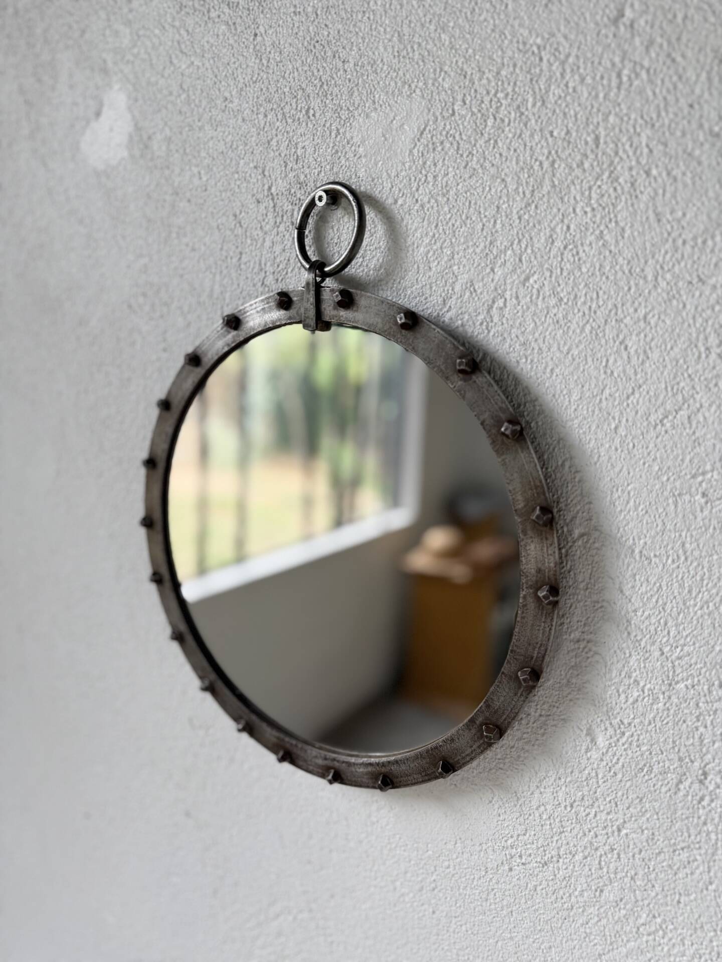 Brutalist round mirror with wrought iron and studs.
