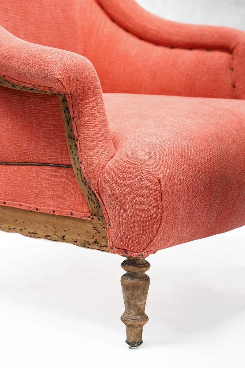 Napoleon III salon armchair in brick red linen with a tufted footrest.