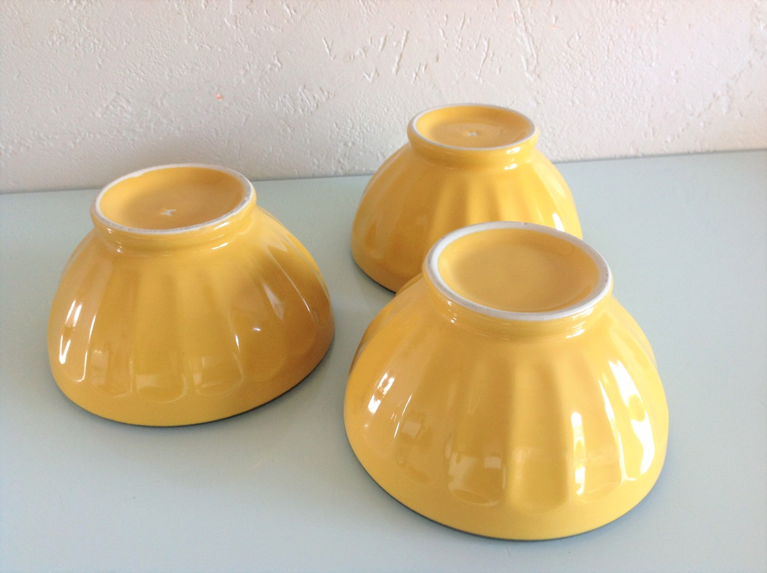 Suite of three yellow ribbed bowls with blue / vintage 70s border