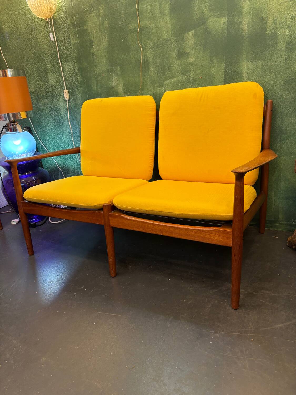 Vintage Scandinavian two-seater bench with mustard yellow cushions.