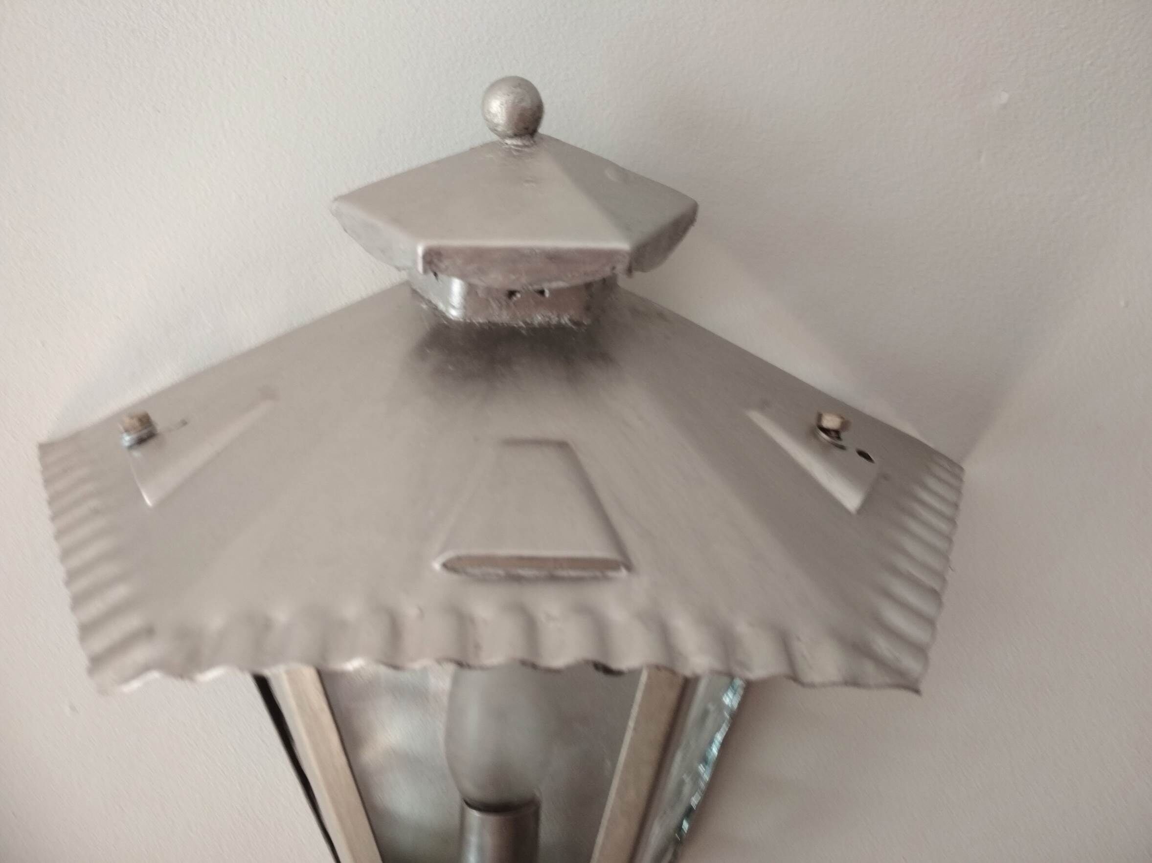 Half grey metal wall sconce and 3 windows