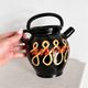 Old vase in glossy black ceramic, vintage exterior decoration.