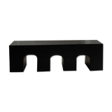 Black solid monoxyl wood bench carved into 3 arches