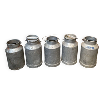 Set of five milk jugs.