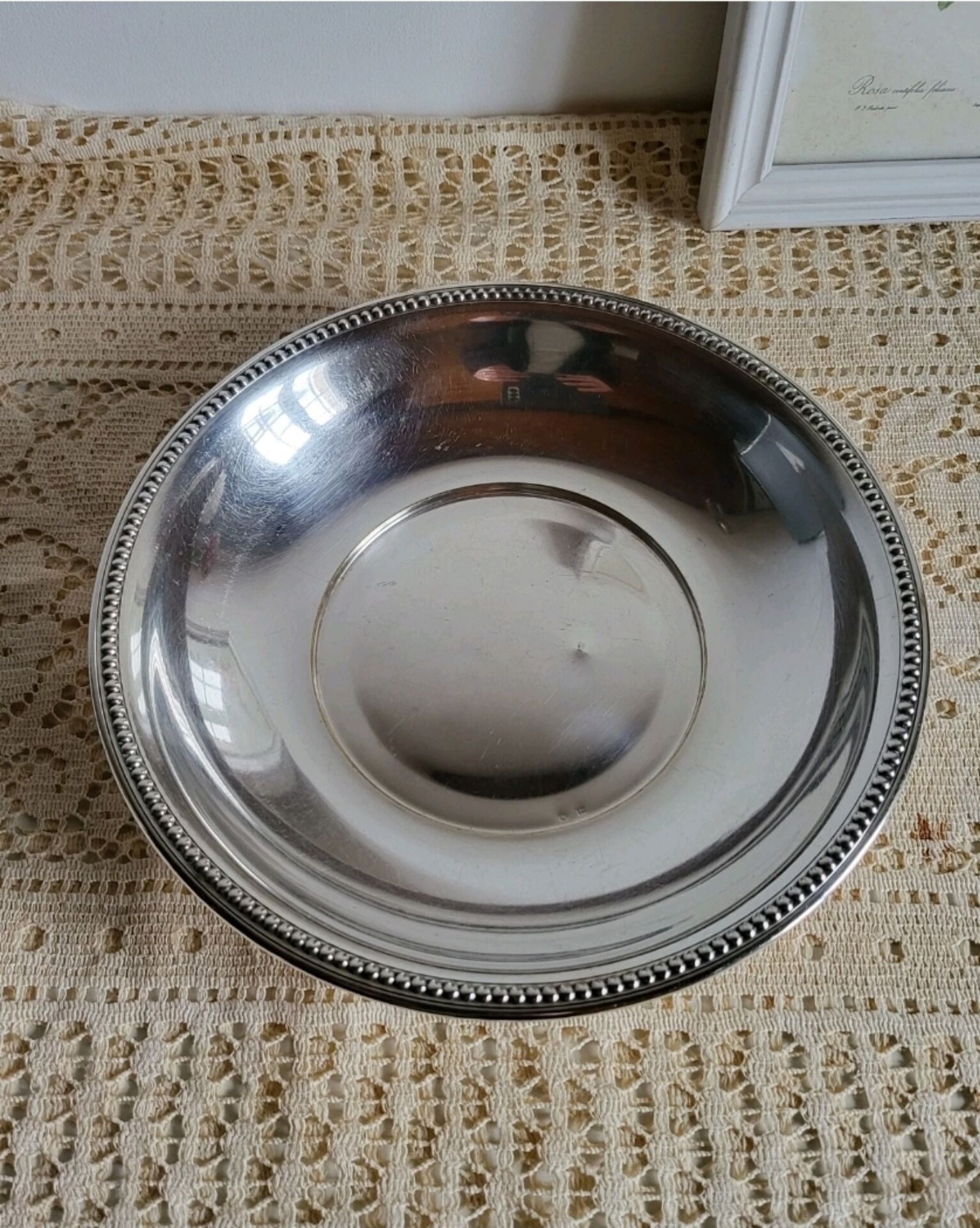 Shallow round metal plate with pearl row decoration.
