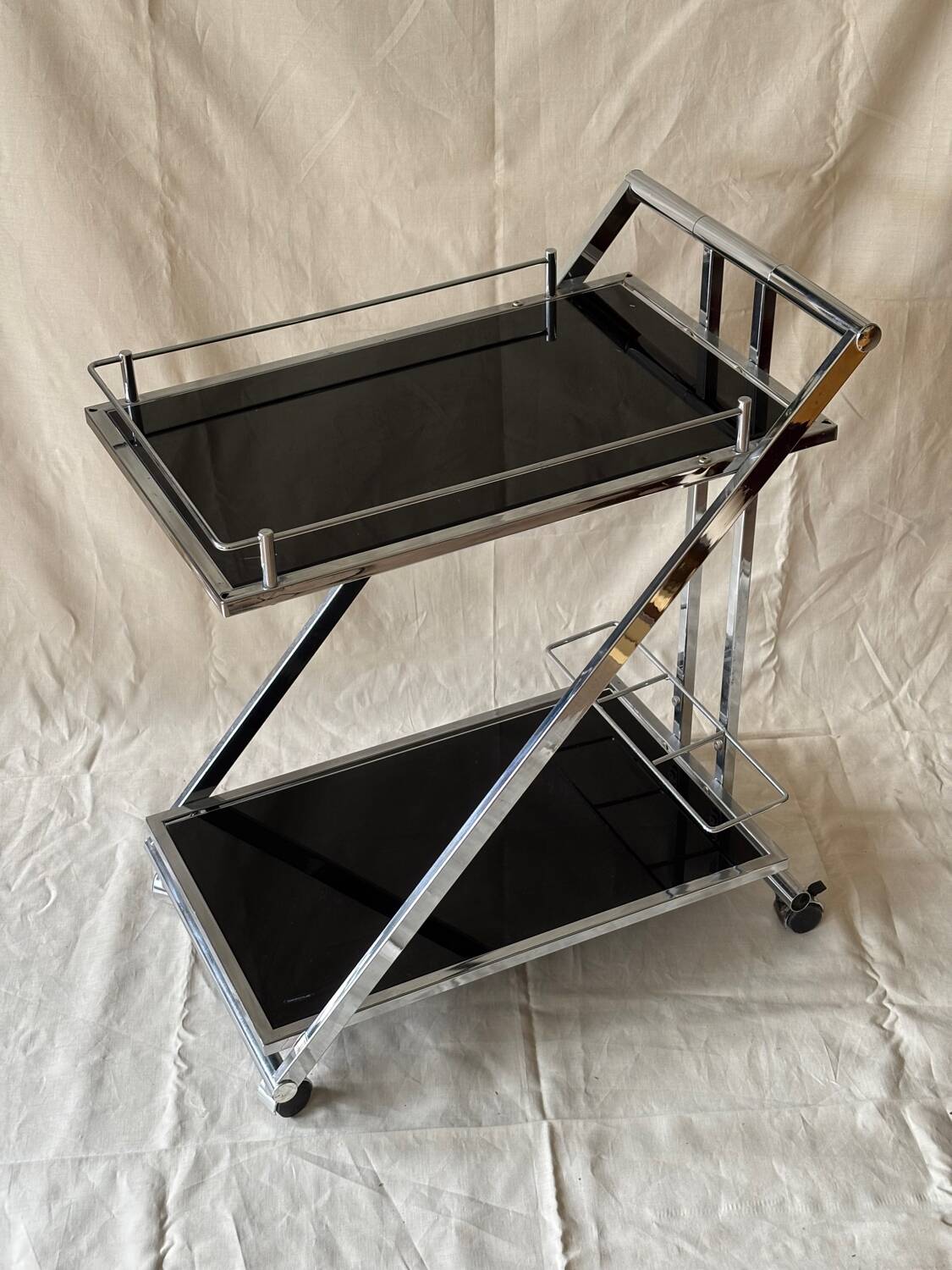 Modernist serving trolley in chromed metal and black smoked glass