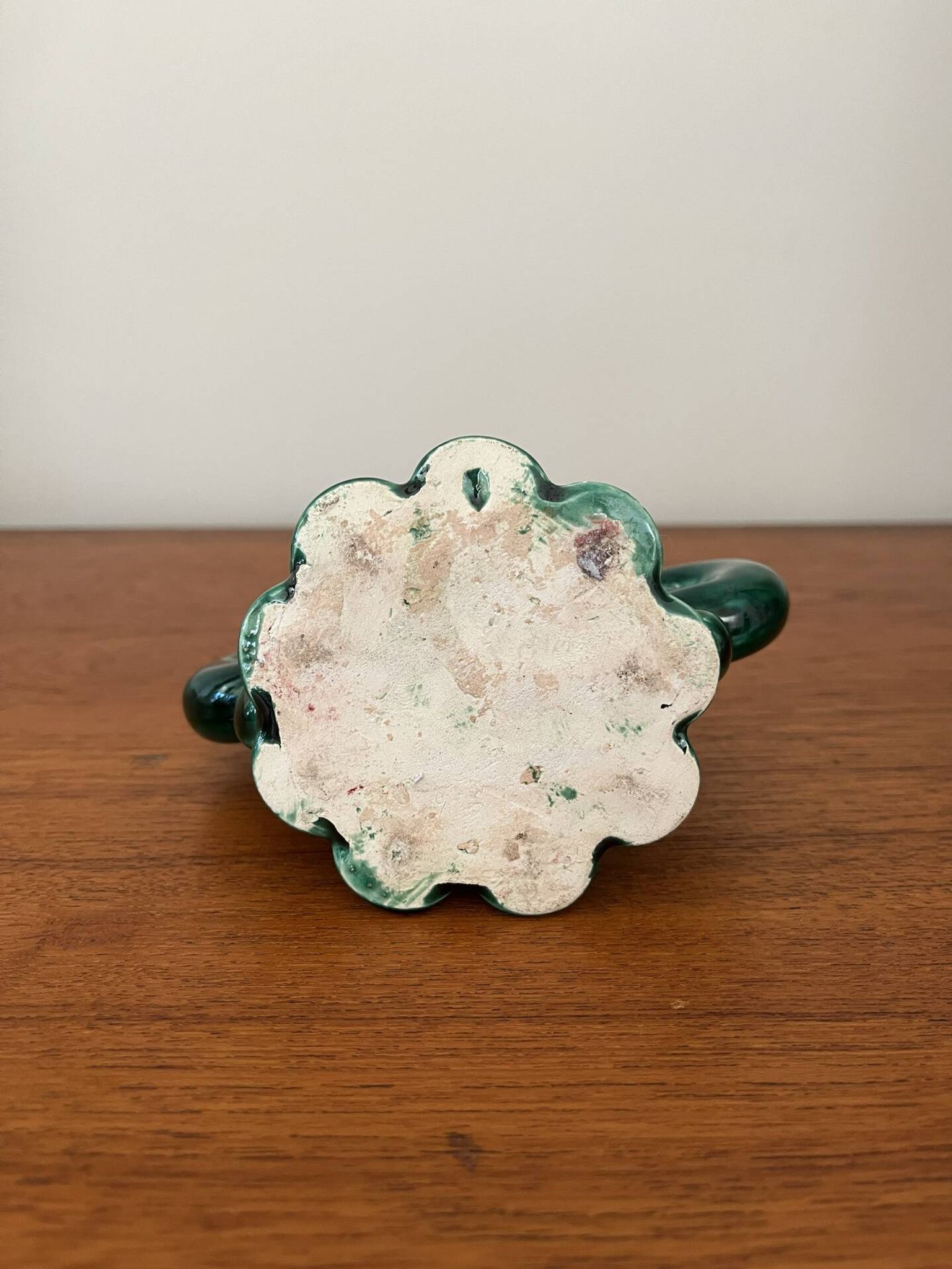 Green ceramic candlestick with curled handles.