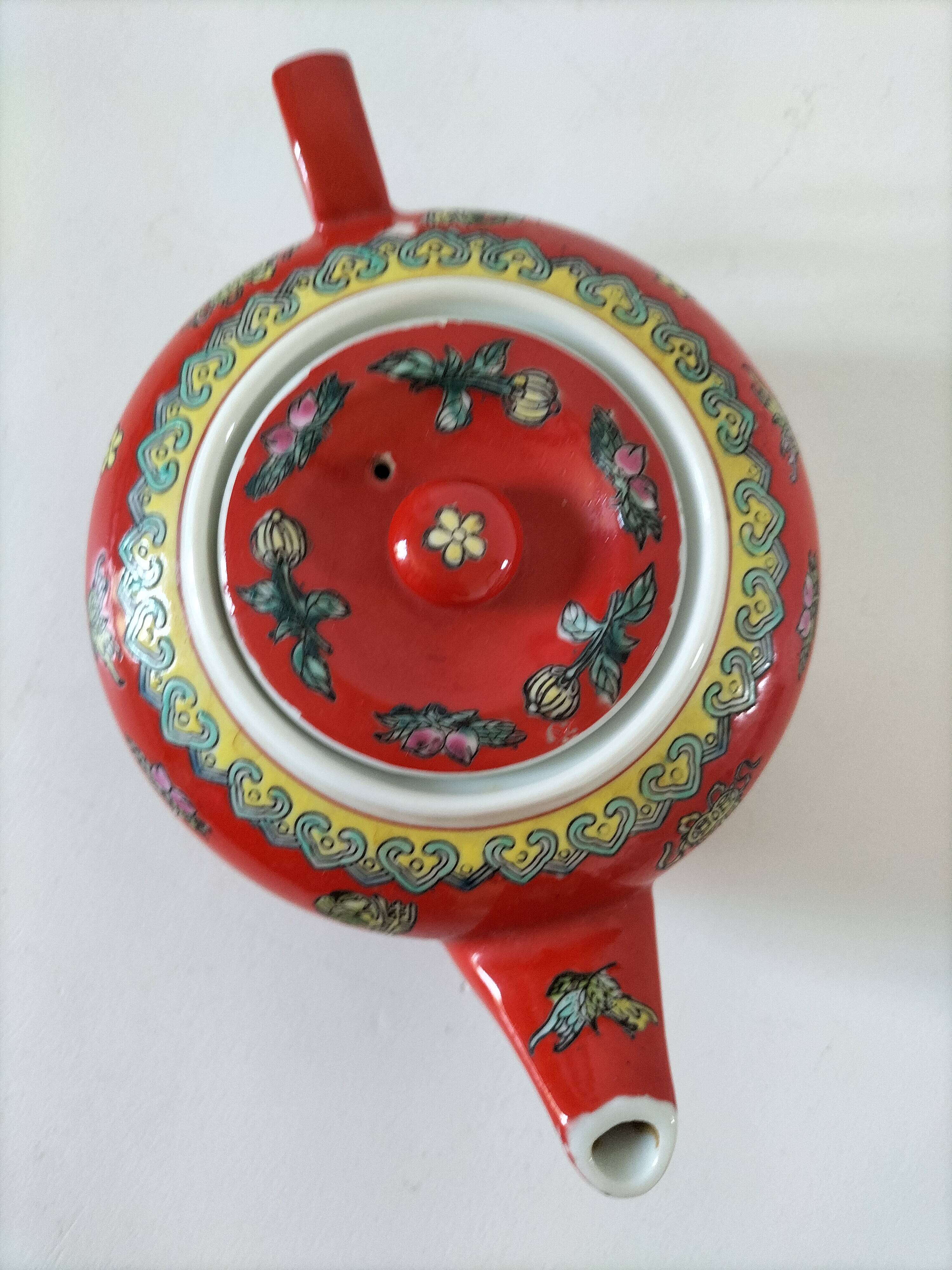Vintage red Chinese teapot decorated with dragons and symbols.