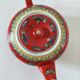 Vintage red Chinese teapot decorated with dragons and symbols.