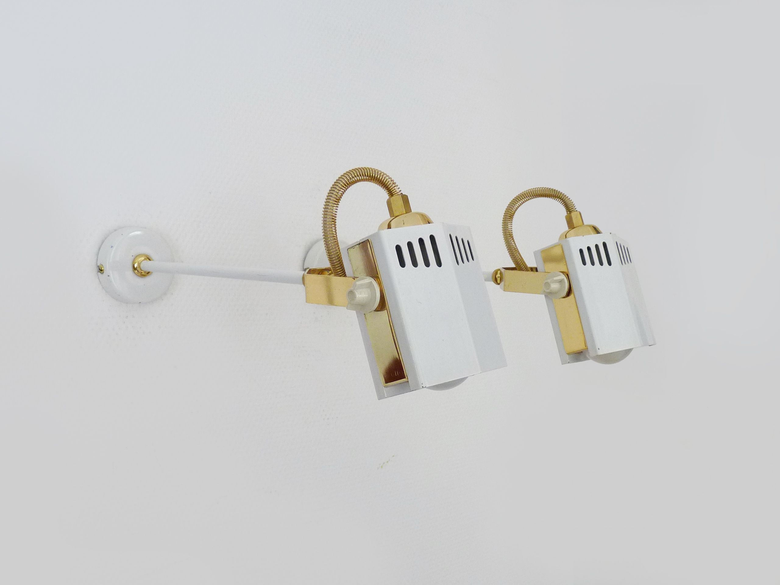 Pair of spot wall lamps adjustable design in white metal and brass. Year 80