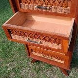 Tall chest of drawers in wood and rattan with splayed legs