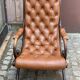 Chesterfield armchair in leather and carved solid wood