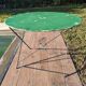 Antique round folding garden table with a green patina.