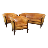 Ensemble ancien unique composé de 2 fauteuils club et d'un canapé en cuir couleur cognac à roulettes
