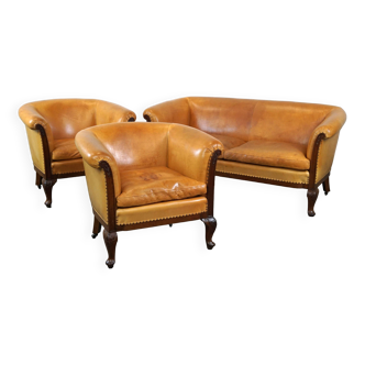 Unique old set of 2 club armchairs and a couch in cognac-colored leather with wheels