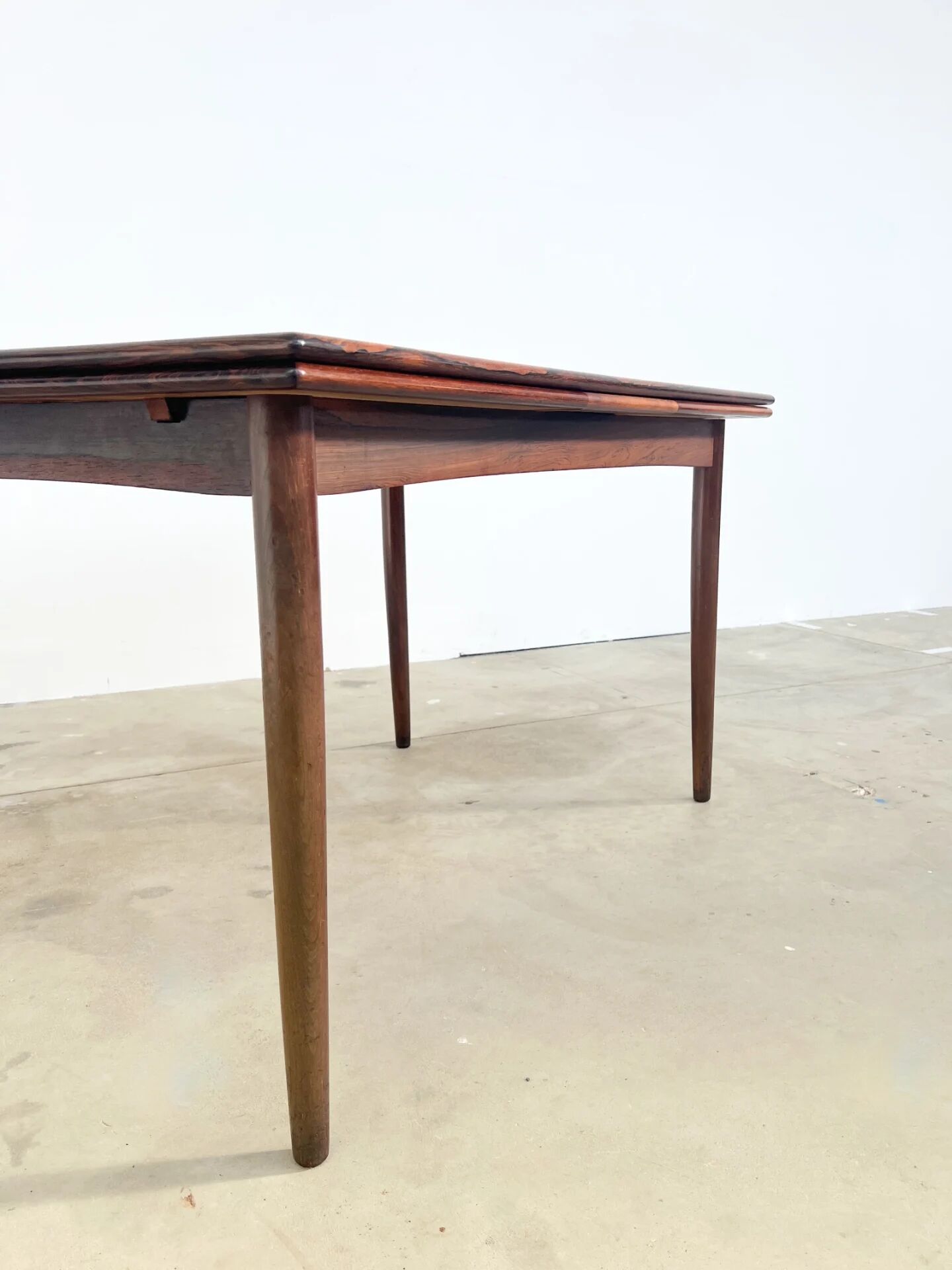 Rosewood dining table with integrated extensions — Denmark, 1960s