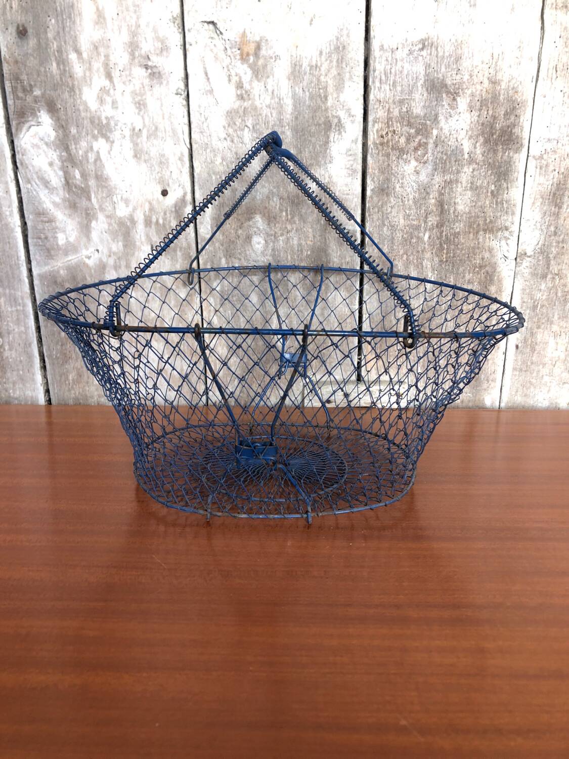 Old foldable blue metal basket, vintage handles